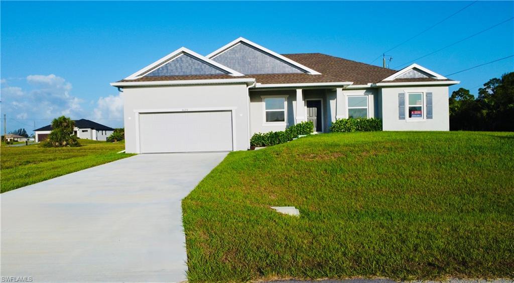 Image 2: Ranch-style house featuring stucco siding, an attached garage, driveway, and a front lawn
