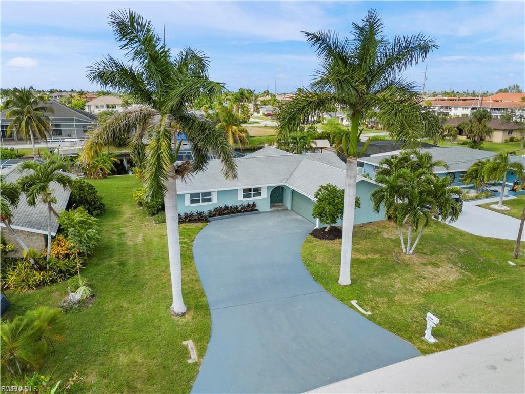 Image 2: View of front of property with concrete driveway, a front yard, an attached garage, and a residential view