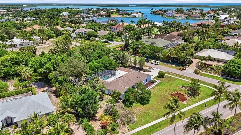 Image 1: Aerial perspective showcasing a residential property with a light-colored roof