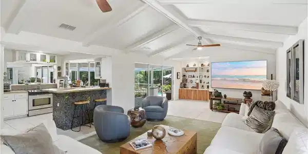 Image 4: Vaulted ceilings with exposed beams and ceiling fans enhance this open-concept living space