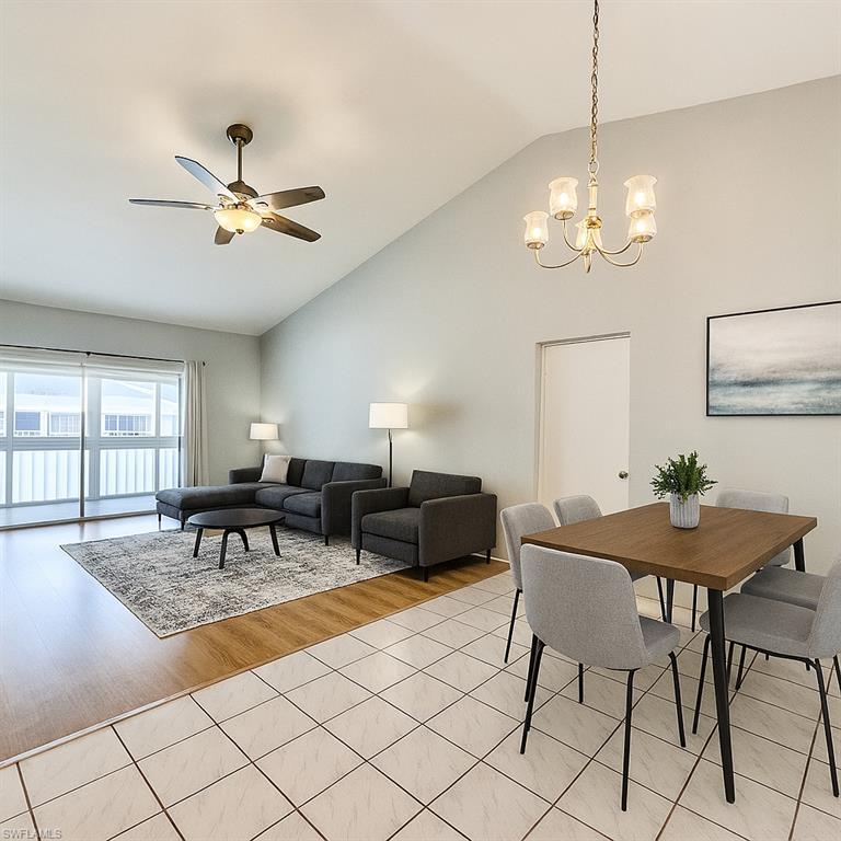 Image 3: Dining room featuring a chandelier, light tile patterned floors, a ceiling fan, and high vaulted ceiling