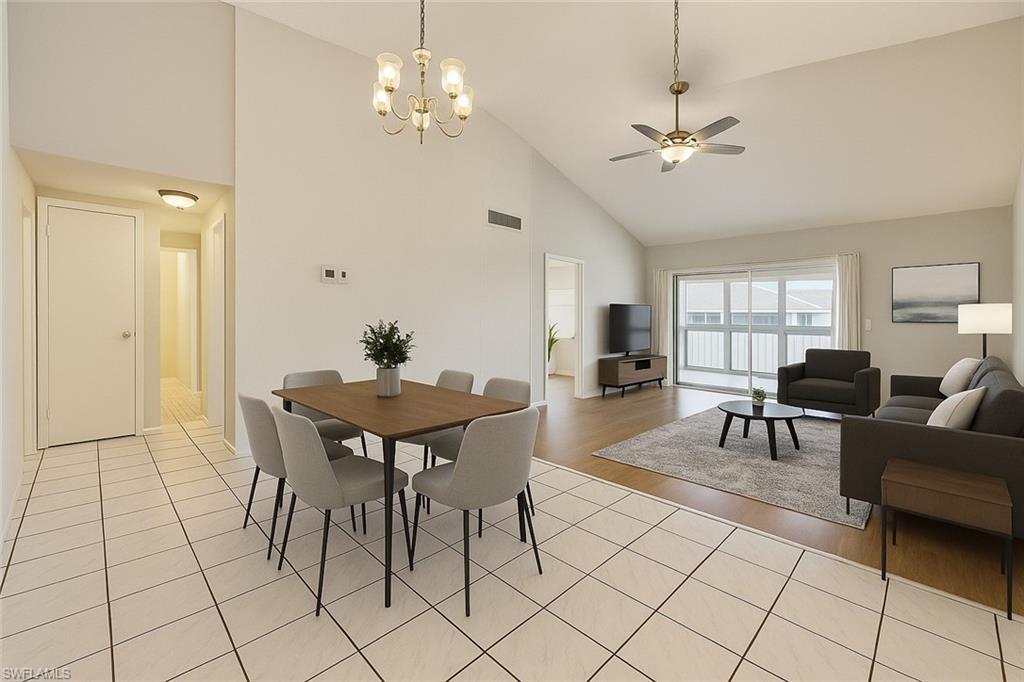 Image 4: Dining space with high vaulted ceiling, a chandelier, light tile patterned flooring, and a ceiling fan