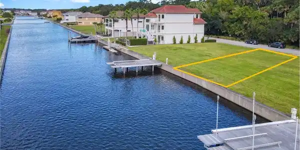 Image 3: Dock featuring a lawn and a water view