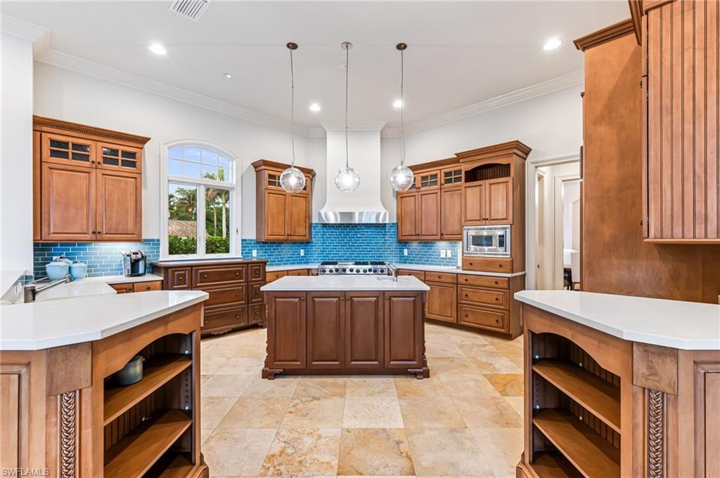 Image 4: Kitchen with pendant lighting, a center island, stainless steel appliances, and tasteful backsplash