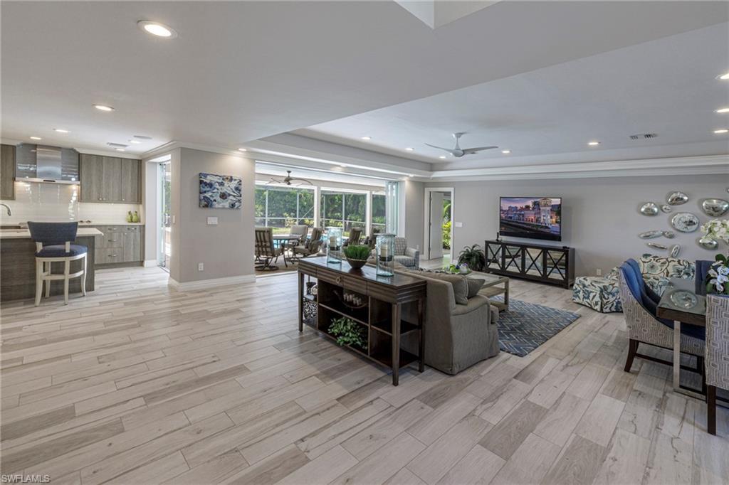 Image 2: Living room featuring ceiling fan, a raised ceiling, light hardwood / wood-style flooring, and crown molding