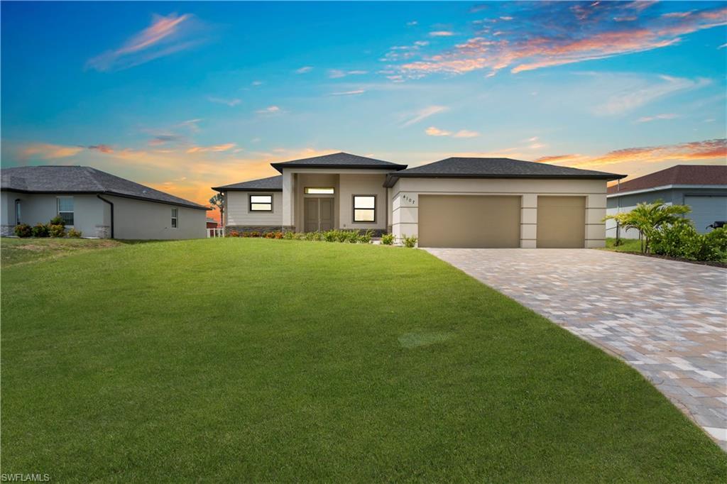 Image 1: Prairie-style house featuring a front lawn, a garage, and decorative driveway