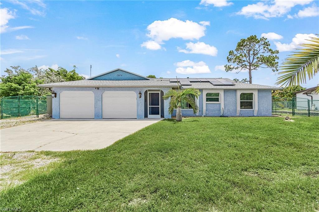 Image 3: Front exterior featuring a light blue stucco finish, a two-car garage, and solar panels