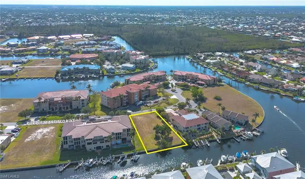 Image 1: Aerial view of residential area with a nearby body of water and property parcel outlined