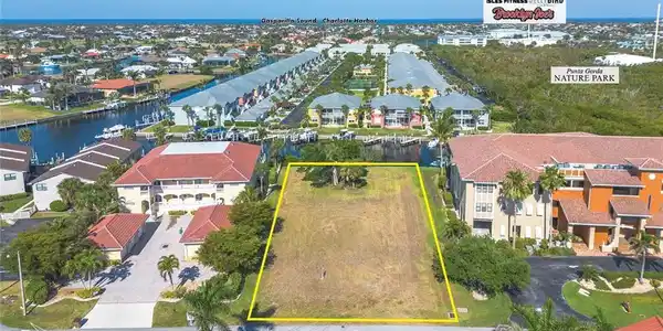 Image 2: Aerial view of residential area featuring a nearby body of water and property boundaries highlighted
