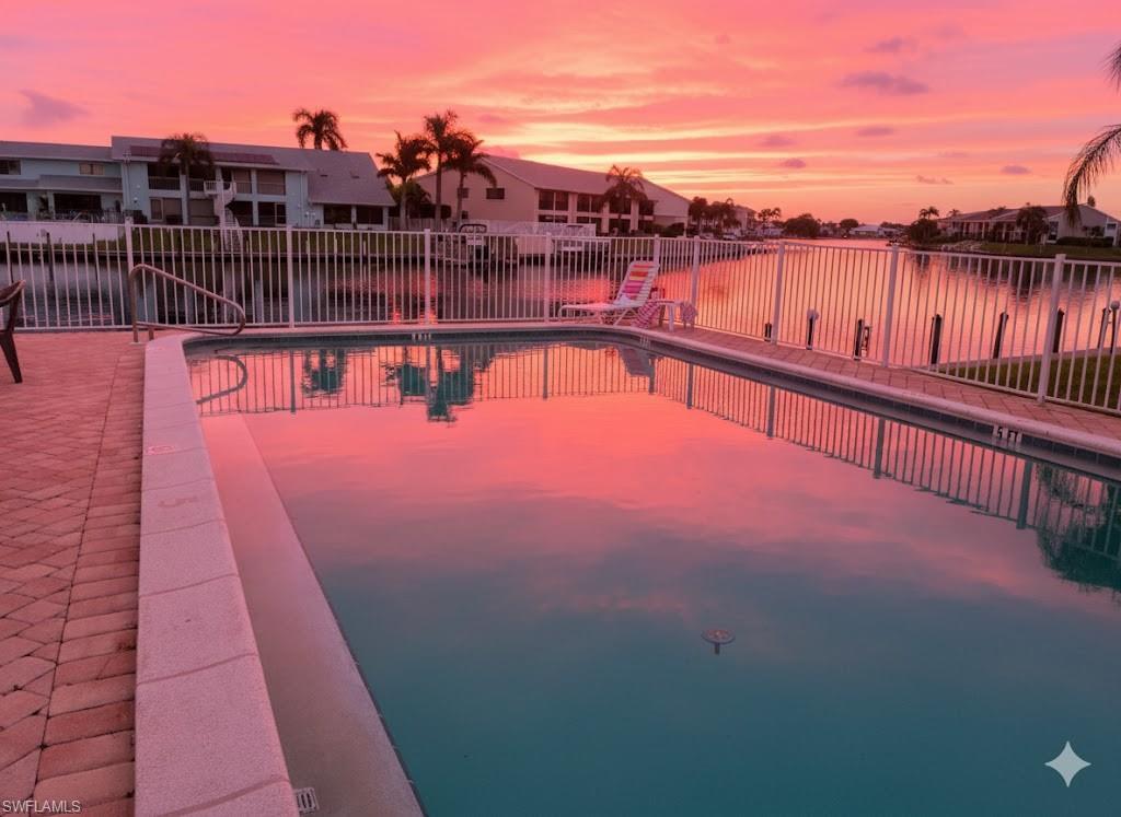 Image 1: Community pool featuring a water view and a residential view