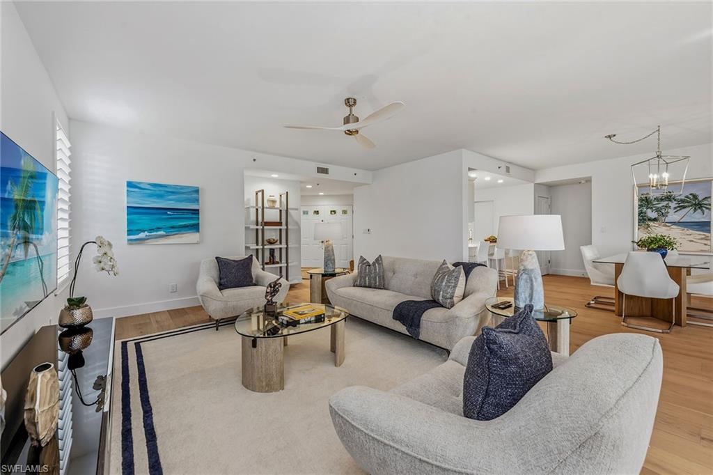 Image 3: Living room featuring light wood-type flooring, ceiling fan, and a chandelier