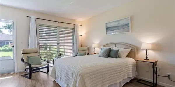 Image 2: Bedroom featuring a textured ceiling, access to exterior, and wood finished floors