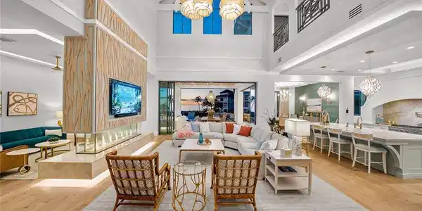 Image 2: Living area with a chandelier, beamed ceiling, light wood-style floors, and high vaulted ceiling