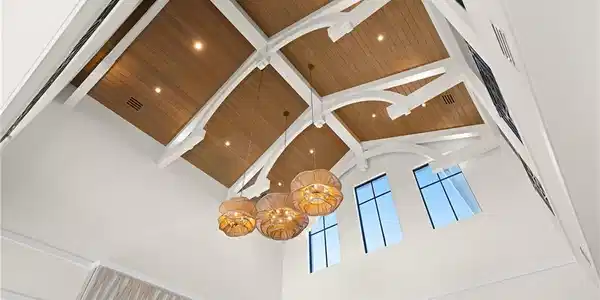 Image 4: Detailed view of a chandelier, a skylight, and a wooden ceiling with exposed beams