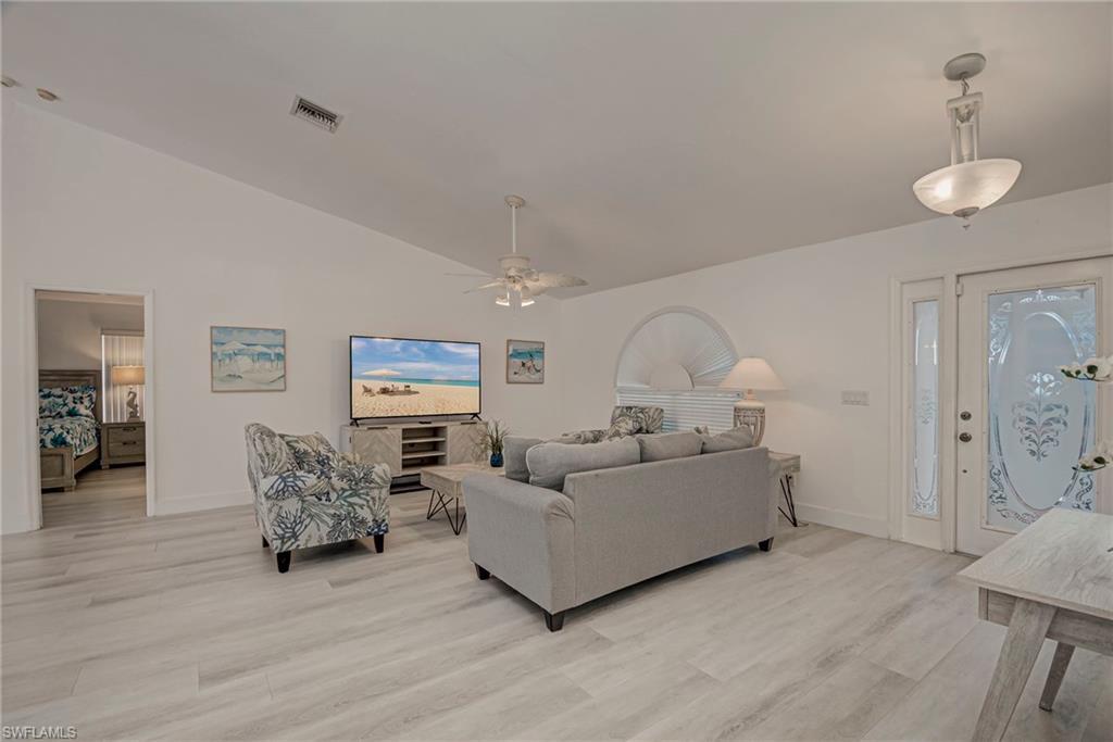 Image 4: Living room with vaulted ceiling, light wood-type flooring, and ceiling fan