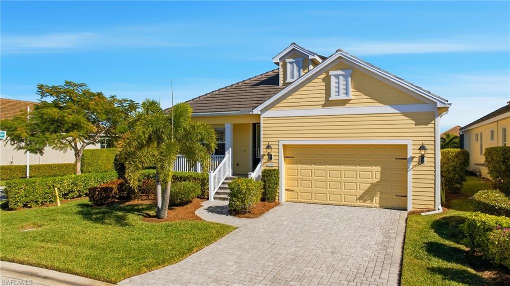 Image 4: View of front facade featuring a front yard, decorative driveway, and an attached garage