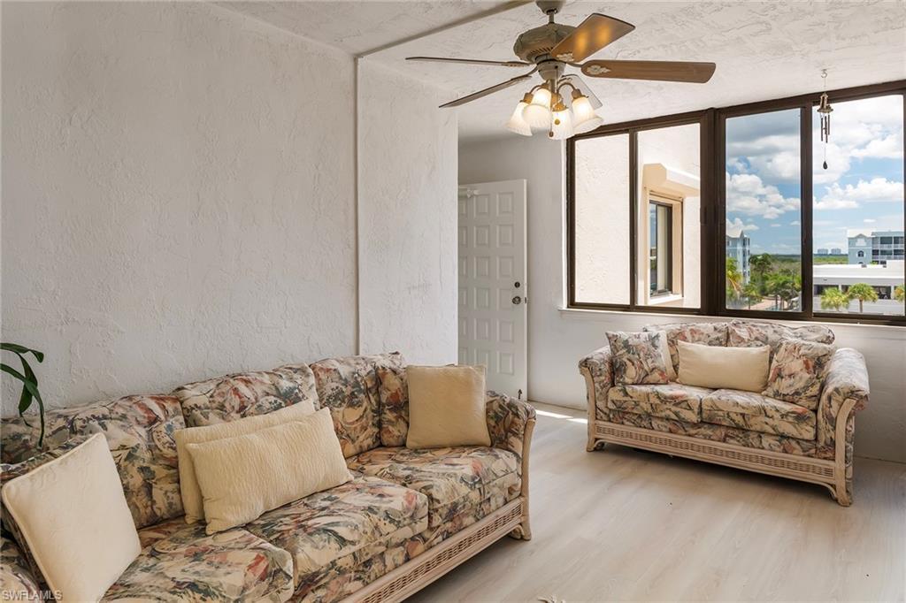 Image 4: Living room with a textured wall, wood finished floors, and a ceiling fan