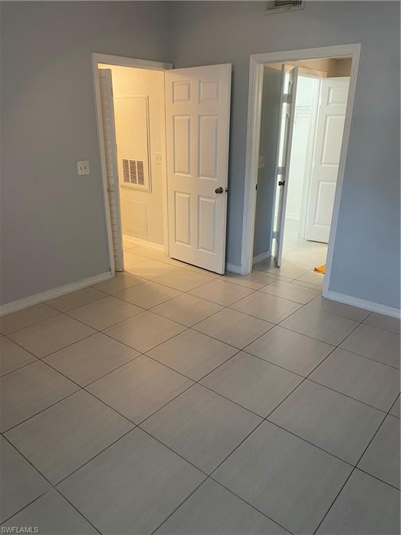 Image 4: Neutral-toned tile flooring extends throughout this interior space, complemented by light gray walls and white trim
