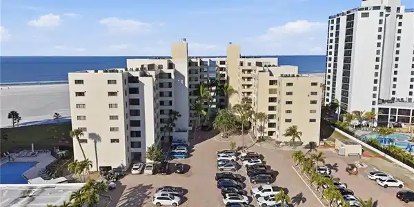 Image 3: View of apartment building / complex with a water view and uncovered parking