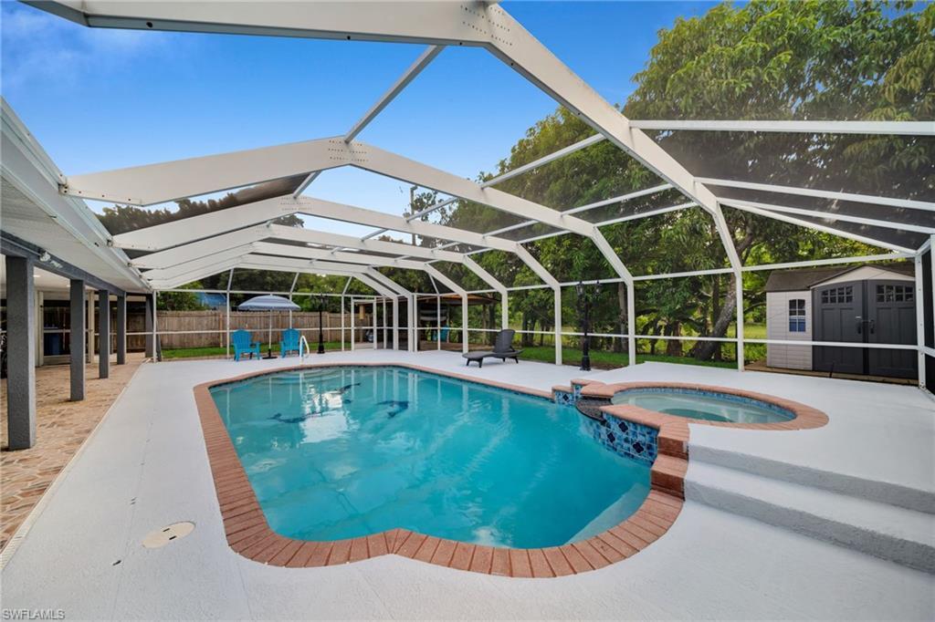 Image 2: Screened outdoor living area featuring a swimming pool, integrated hot tub, and a spacious pool deck