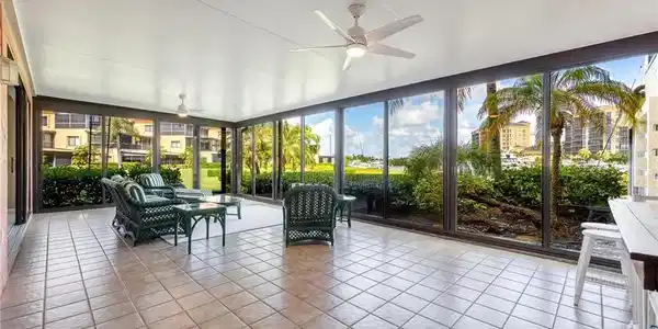 Image 4: Screened lanai featuring tile flooring, ceiling fans, and a full wall of floor-to-ceiling windows