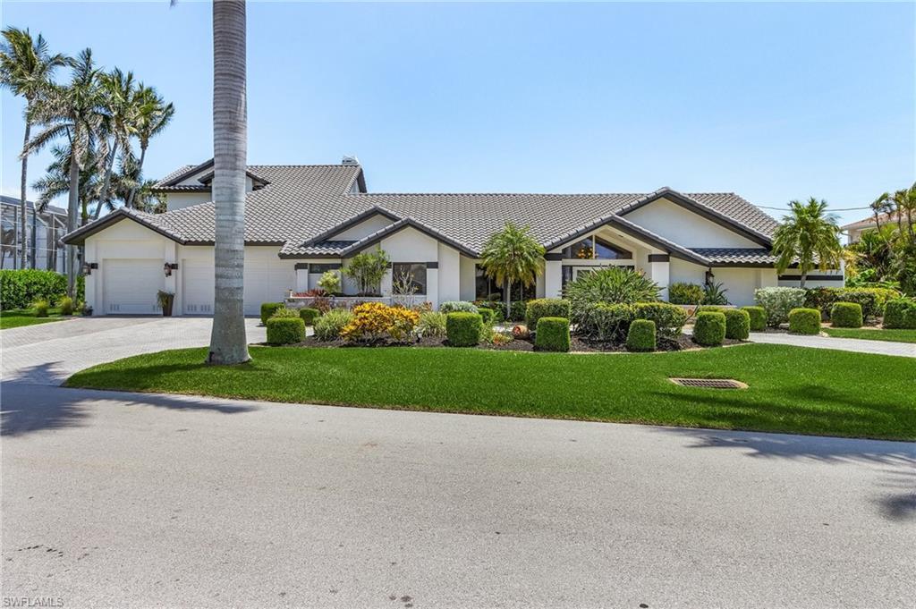 Image 3: View of front of property featuring a tiled roof, driveway, a front yard, a garage, and stucco siding
