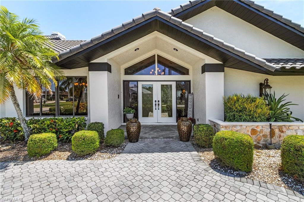 Image 4: View of exterior entry featuring french doors, a tile roof, and stucco sidingWelcome Home