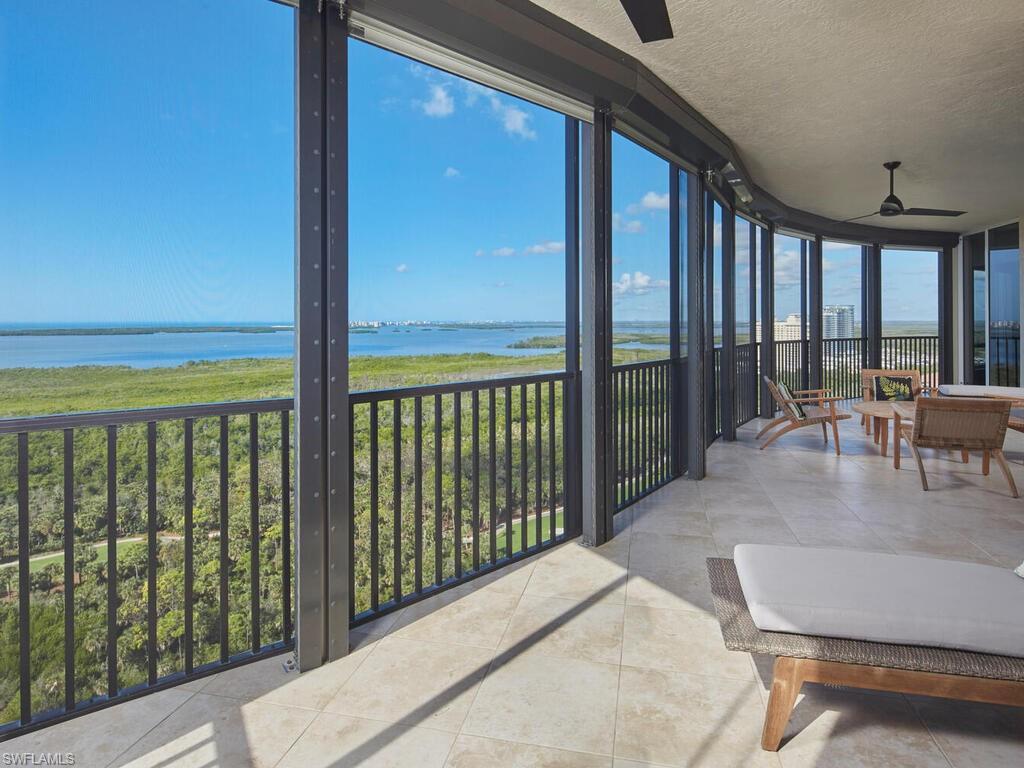 Image 3: Sunroom featuring a wall of windows, a water view, a textured ceiling, and tile patterned floors