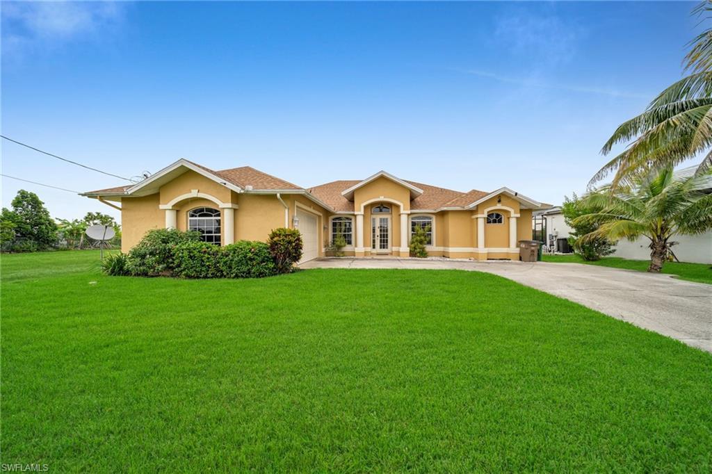 Image 1: View of front facade featuring stucco siding, concrete driveway, a front lawn, and an attached garage
