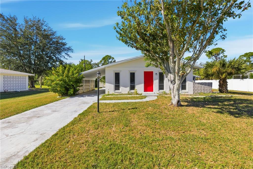 Image 2: Ranch-style house with driveway, stucco siding, and an attached carport