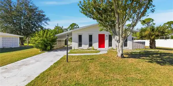 Image 2: Ranch-style house with driveway, stucco siding, and an attached carport