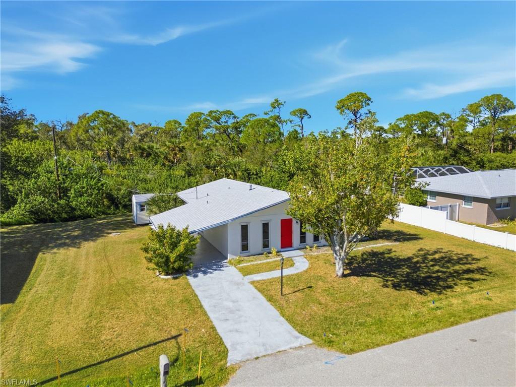 Image 4: View of front of property with driveway and an attached carport