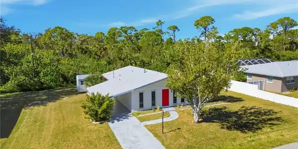 Image 4: View of front of property with driveway and an attached carport