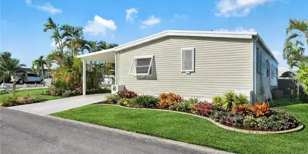 Image 3: Front exterior showcasing the POTENTIAL low-maintenance landscaping and inviting entrance to this move-in ready St. James City home. *AI ENHANCED