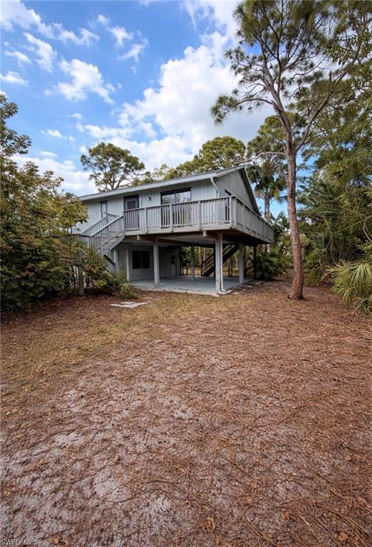 Image 3: Rear view of property featuring a wooden deck, a patio, and a carport