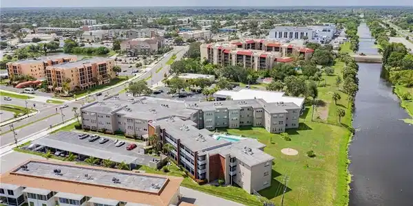 Image 4: Aerial view of a large body of water and apartment complex / building