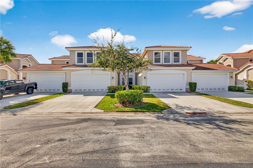 Image 1: Mediterranean / spanish home with a tiled roof, stucco siding, and driveway