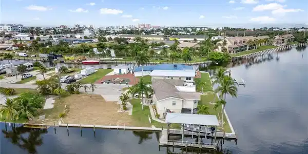 Image 3: Aerial view of residential area featuring a nearby body of water