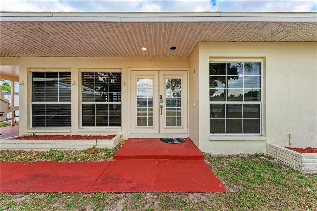 Image 3: View of exterior entry with french doors and stucco siding