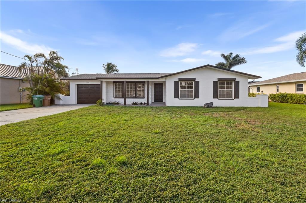 Image 3: Single story home featuring driveway, a garage, a front yard, and stucco siding