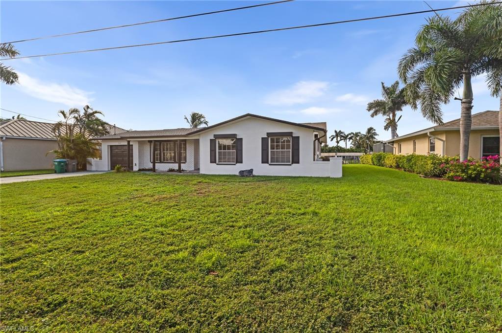 Image 4: Ranch-style home with a front yard, a garage, stucco siding, and driveway
