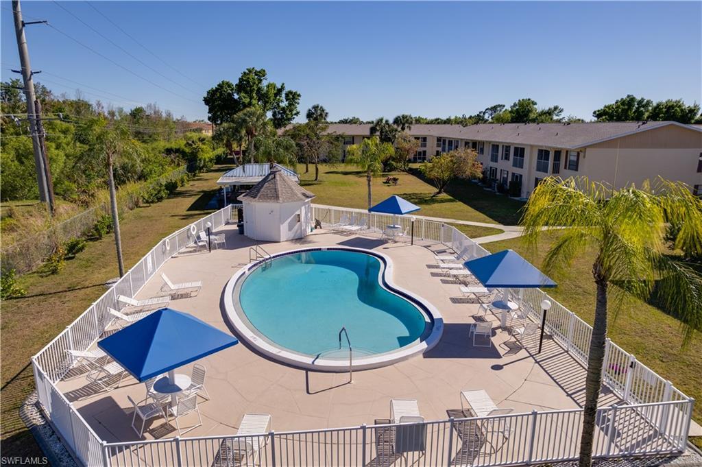 Image 2: Community pool with a patio area and a grill
