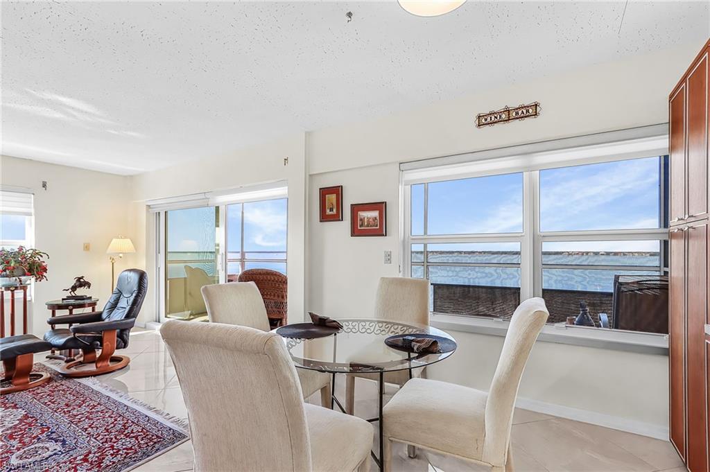 Image 3: Dining space featuring light tile patterned floors, a textured ceiling, healthy amount of natural light, and a water view