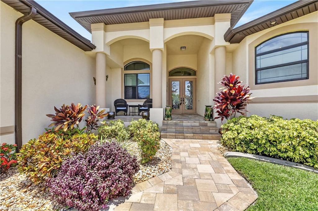 Image 1: Elegant stucco exterior featuring arched entryways, decorative columns, and a double-door entry with etched glass
