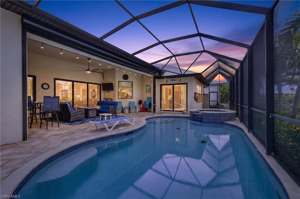 Image 4: Screened lanai featuring a swimming pool with integrated spa