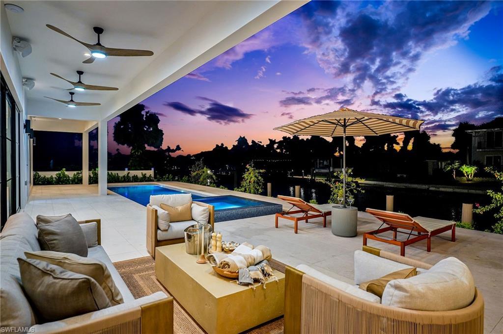 Image 1: Pool at dusk with an outdoor living space and a patio area