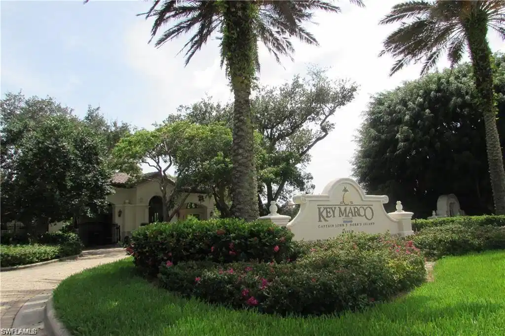 Image 1: "Key Marco" stone entry monument surrounded by mature landscaping
