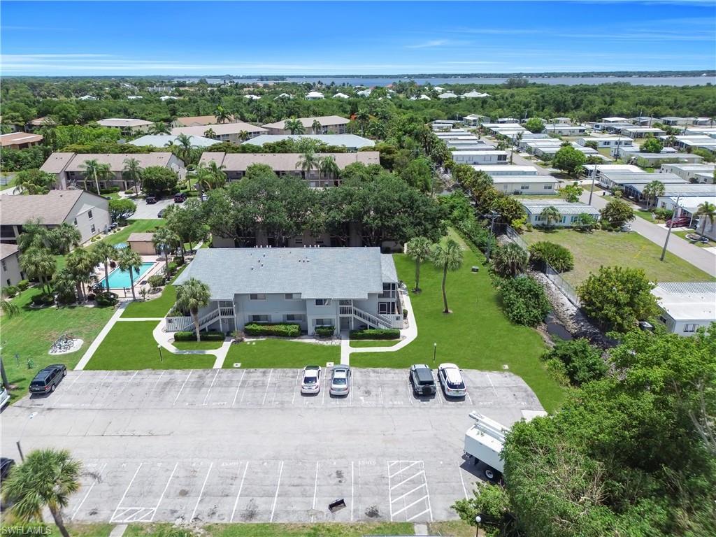 Image 3: Multi-unit dwelling featuring a central courtyard with established landscaping, a community pool, and ample surface parking