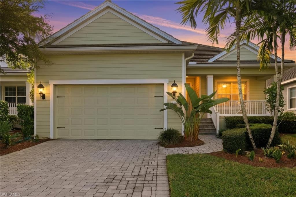 Image 1: View of front of house with covered porch, decorative driveway, and an attached garage