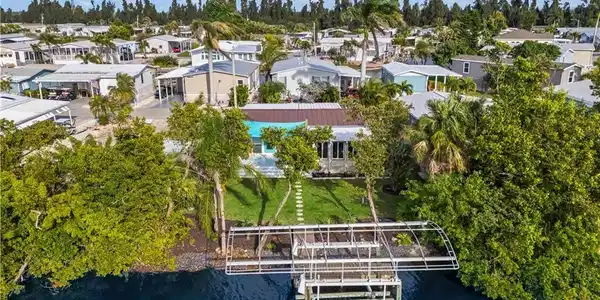 Image 4: Situated on scenic canal, this 2 BED + 2 BATH manufactured HOME features PRIVATE DOCK & 10K-lb BOAT LIFT